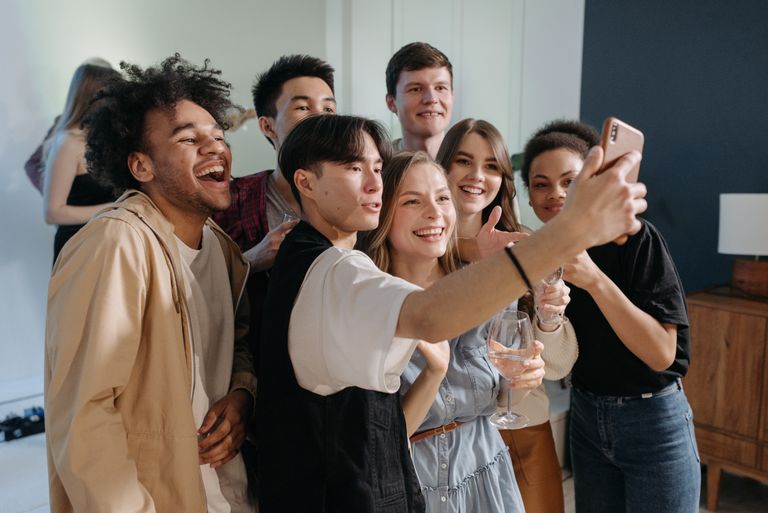 A diverse group of friends taking a cheerful selfie together indoors.